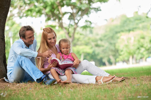 Family at a park reading.