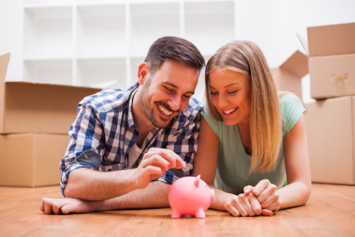 A couple putting money into a piggy bank.