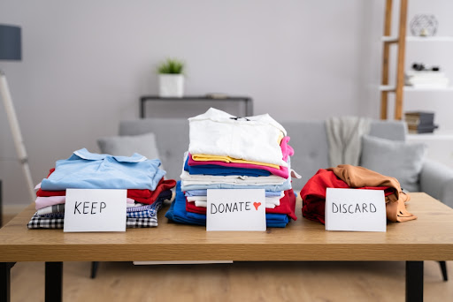 Piles of clothes labeled "keep" "donate" and "discard".