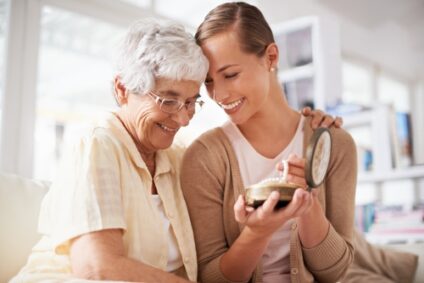 Elderly woman and her child hugging and holding a jewelry box.