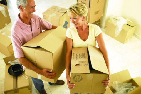 older couple holding moving boxes