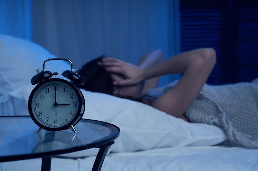 Person waking up in the dark to an alarm clock.
