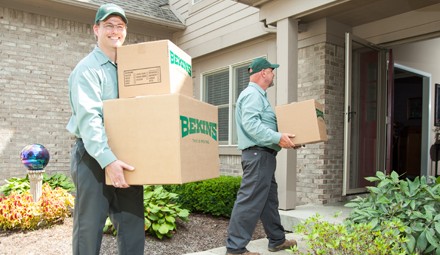 bekins workers bringing boxes inside new home