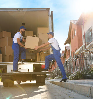 Two professional movers unload boxes from a moving truck.