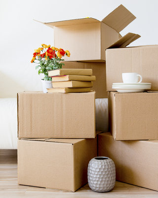 moving boxes and items stacked in front of couch