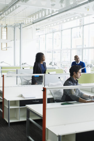 Colleagues talking at workstations