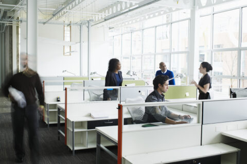 Colleagues talking at workstations