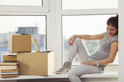 Woman sitting in window after moving into new apartment