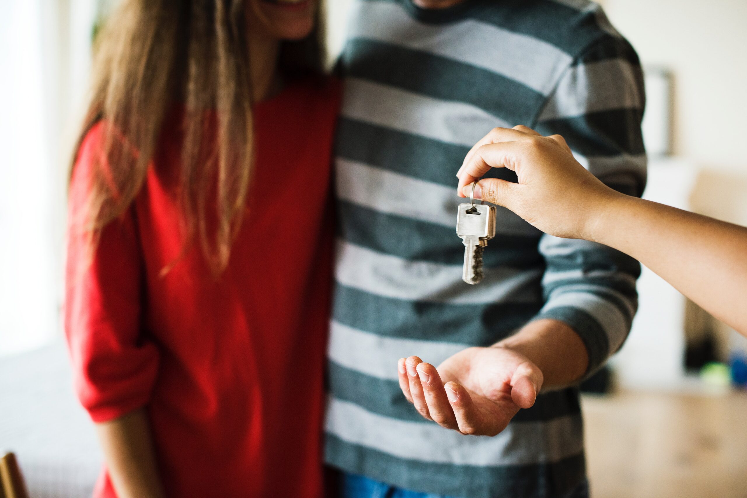 person handing keys to a couple