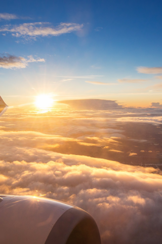 view of sunrise and clouds from an airplane window