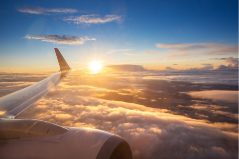 view of sunrise and clouds from an airplane window