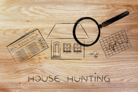magnifying glass analyzing a house, with sector newspaper, stats and keys