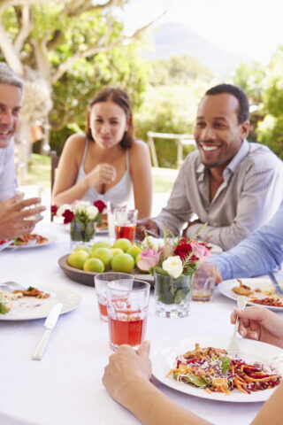 Friends dining together at a table in a garden