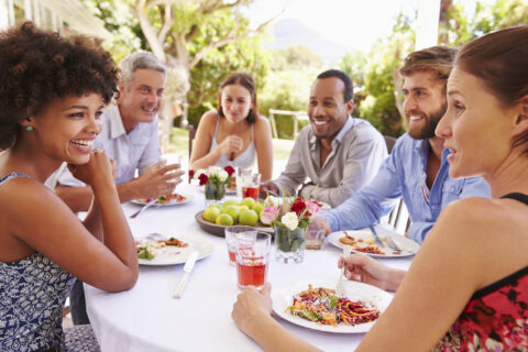 Friends dining together at a table in a garden