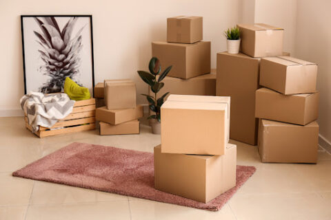 Stacks of moving boxes with fragile items on top.