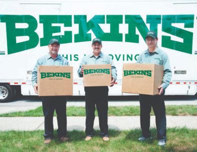 Smiling Bekins agents hold boxes in front of moving van.