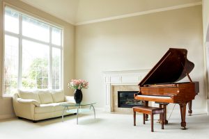 Piano and couch in room of nice house.