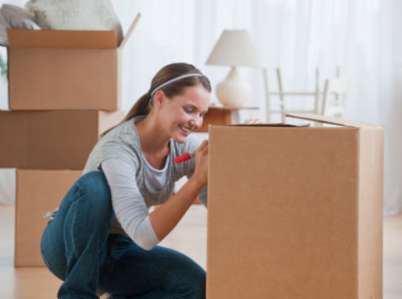 woman writing on a packing box