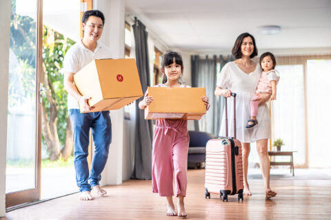Large family carrying boxes into their new home
