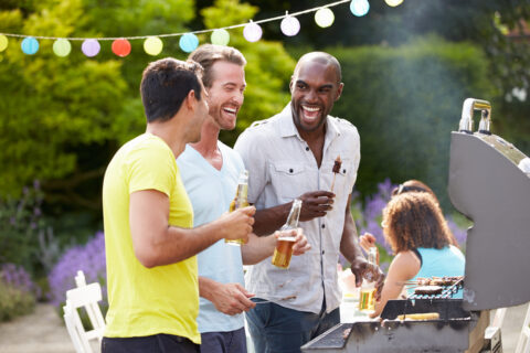 Group Of Men Cooking On Barbeque At Home