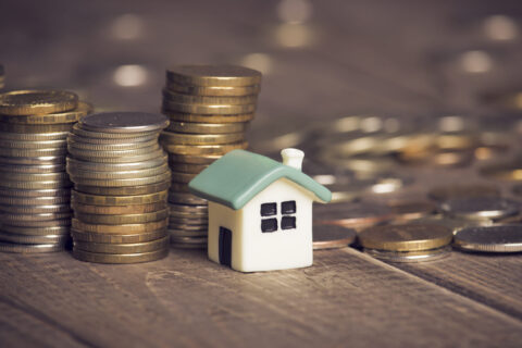mortgage payment: coins sitting by house
