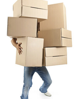 A person trying to balance a bunch of boxes in their arms.