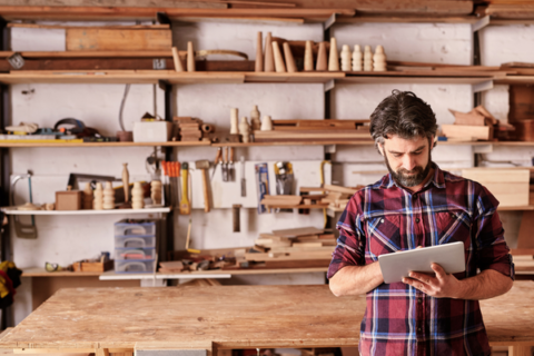 Small business owner consulting a list on his clipboard. How to move shop when you're a small business owner