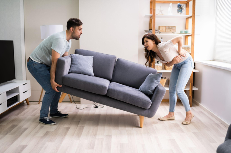 people moving a gray couch