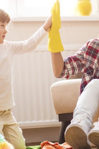 A child and an adult high-fiving after cleaning.