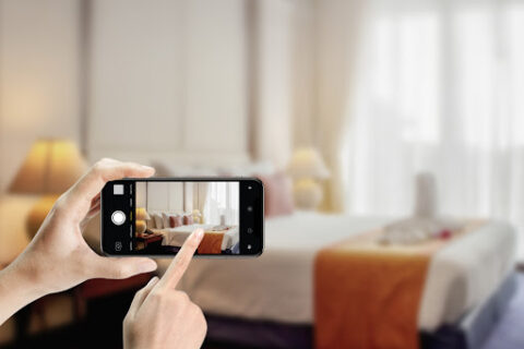 Close up of hands holding smartphone take photo bedroom at hotel