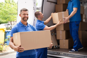 Movers loading boxes onto moving truck.