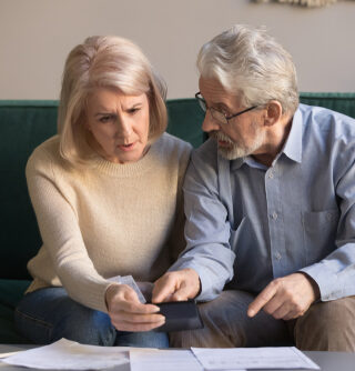 Serious senior couple, stressed about paperwork.