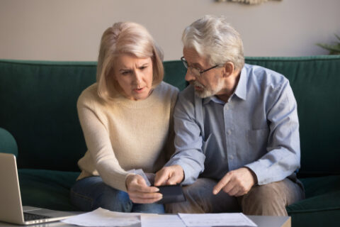 Serious senior couple, stressed about paperwork.