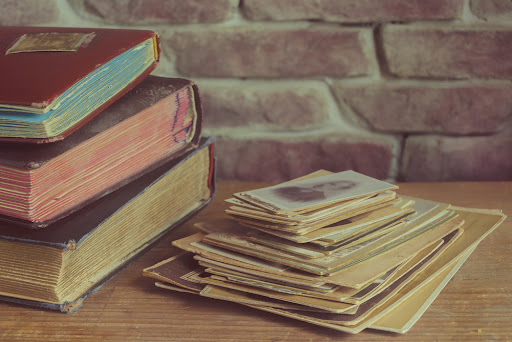 Closeup of old books and photos on a table.