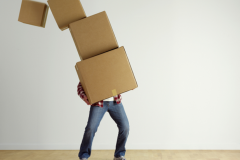 man holding a falling stack of boxes