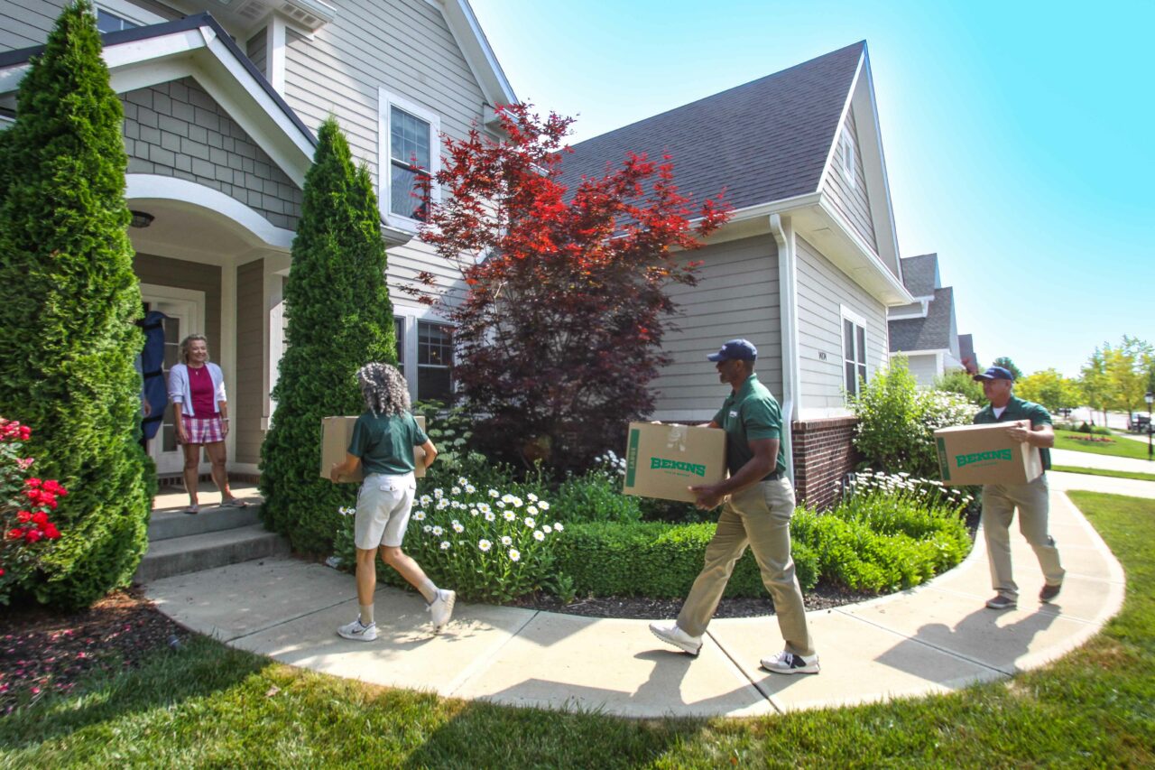 Bekins movers walking towards a house.