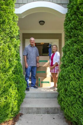 A couple standing next to boxes.