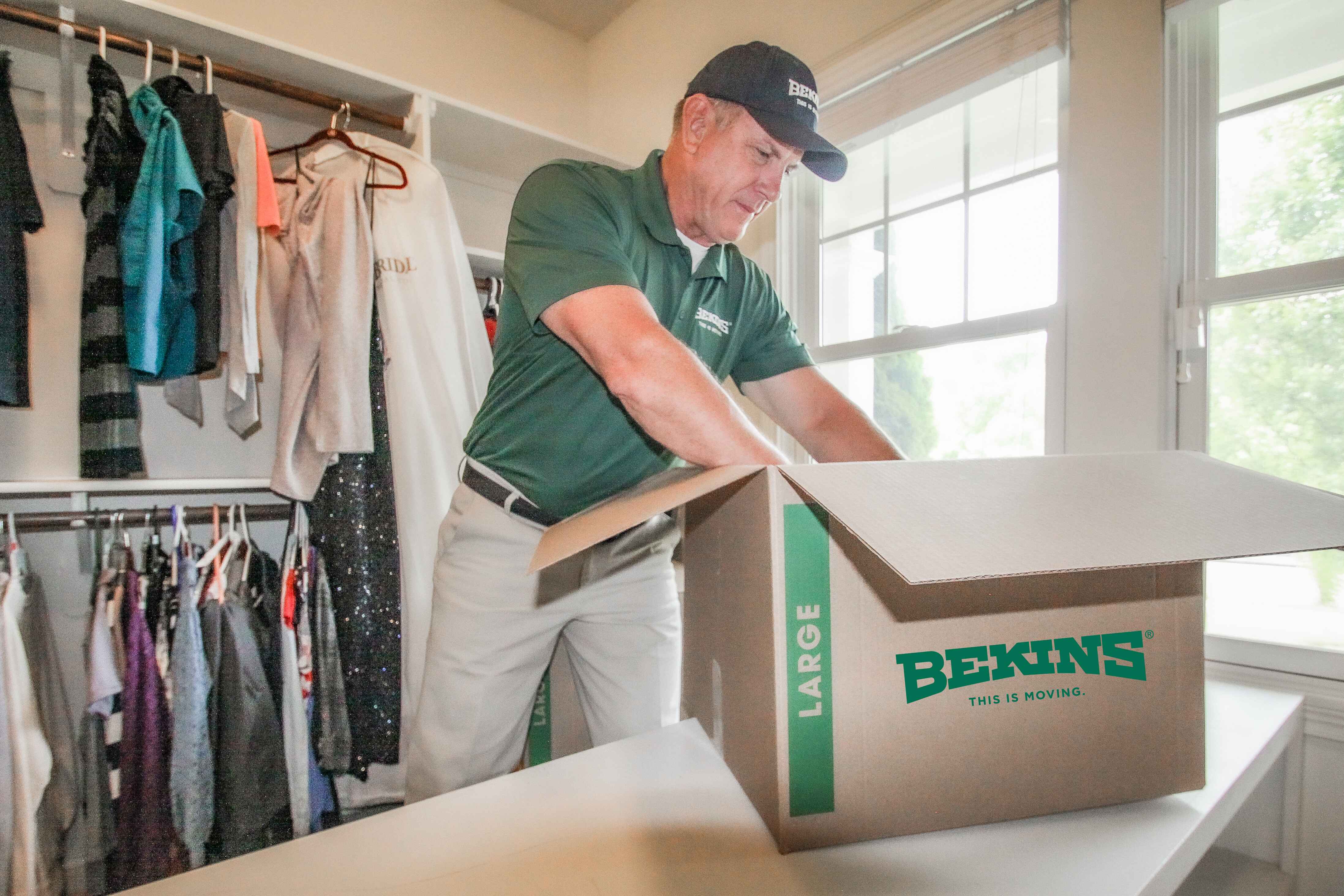 Bekins mover packing clothes.