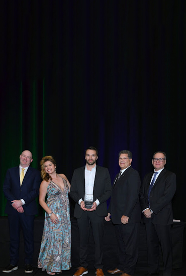 5 people holding an award.