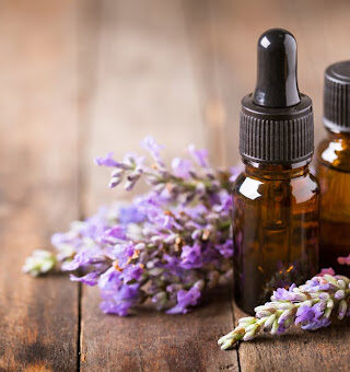 Small essential oil bottles surrounded by lavender buds.