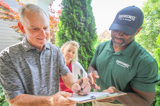 Elderly couple with bekins employee.