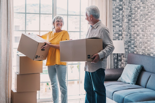 Elderly couple holding boxes.