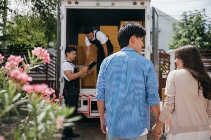 A couple next to a moving truck.