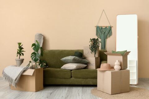 A living room with moving boxes and a large mirror.